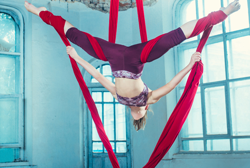 Graceful gymnast performing aerial exercise